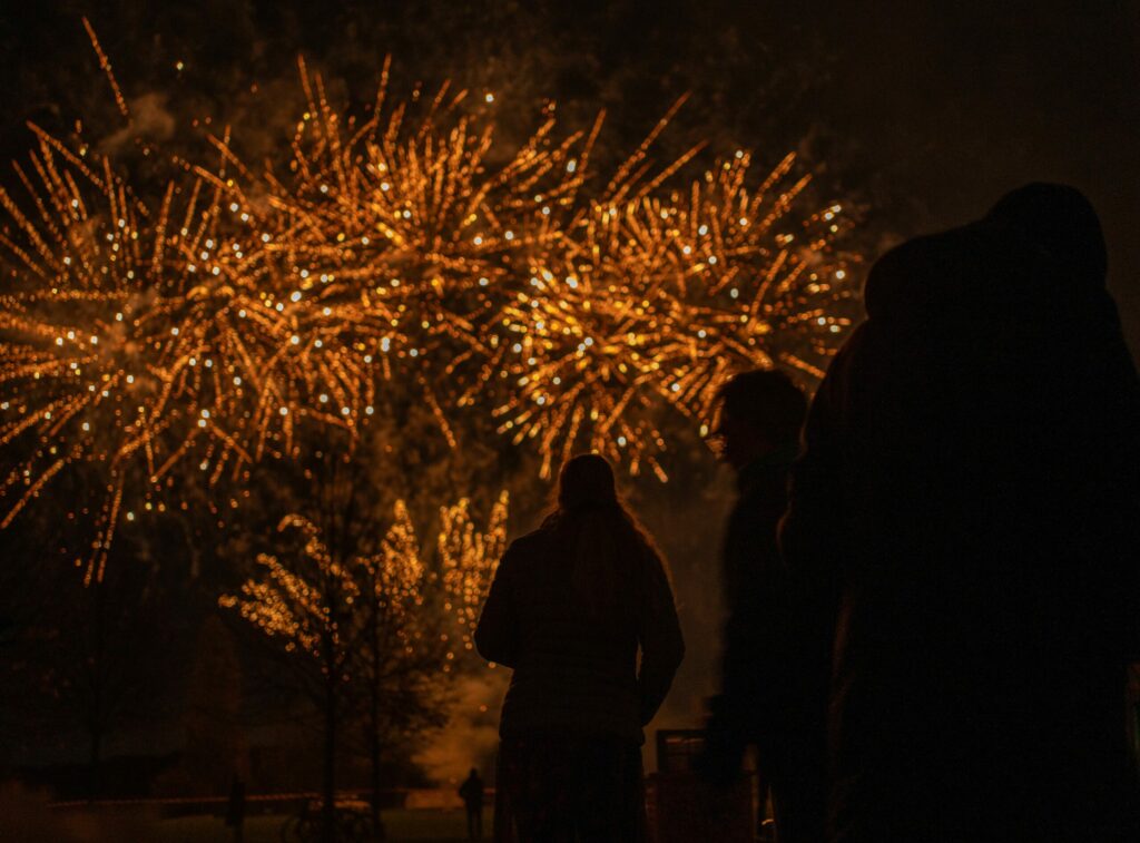 Menschen beobachten Feuerwerk bei den Bremer Lichtern, festliche Silhouette bei Nacht.